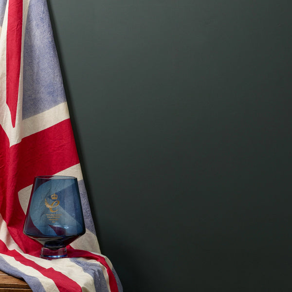 Tummanvihreää seinää vasten brittien lippu ja lasinen Frenchic sajan Queens Award palkintomalja.